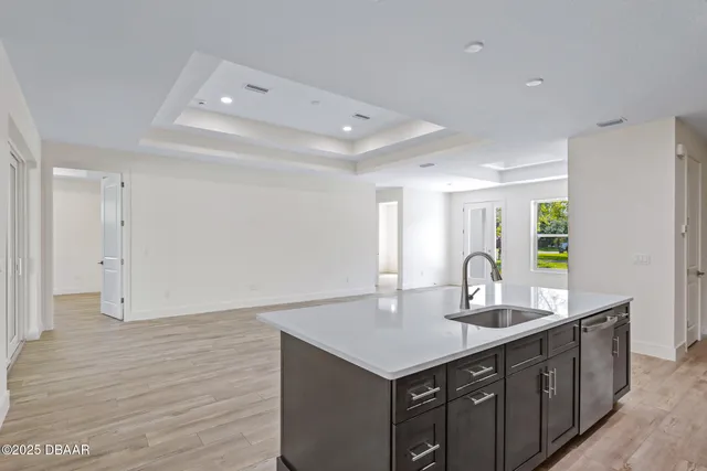 a kitchen with a sink cabinets and wooden floor