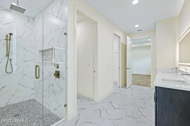 a bathroom with a granite countertop shower a sink and a mirror