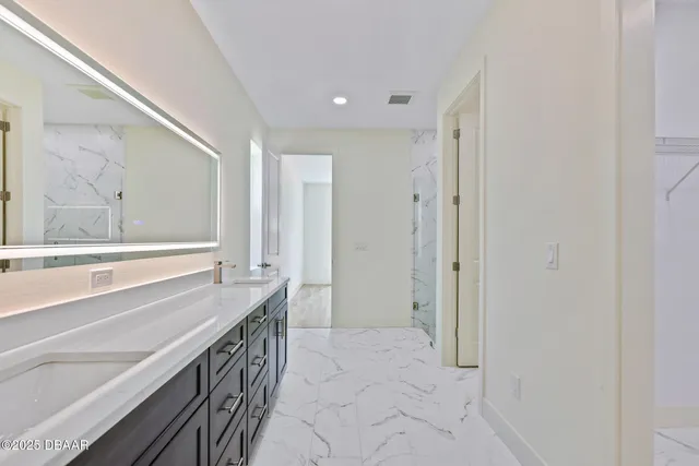 a spacious bathroom with a granite countertop sink mirror and a bathtub