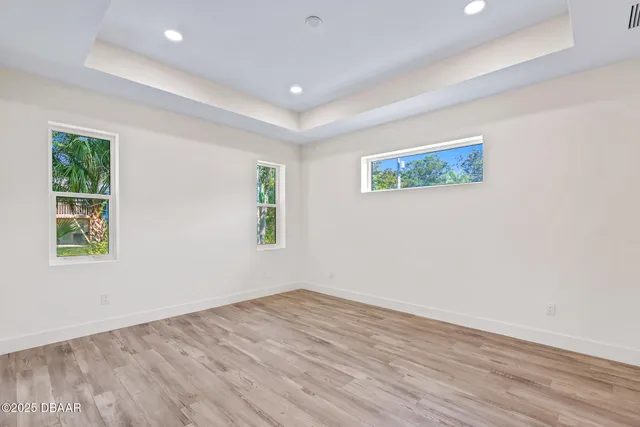 an empty room with wooden floor and window