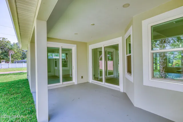 a yellow house with a big yard and large trees