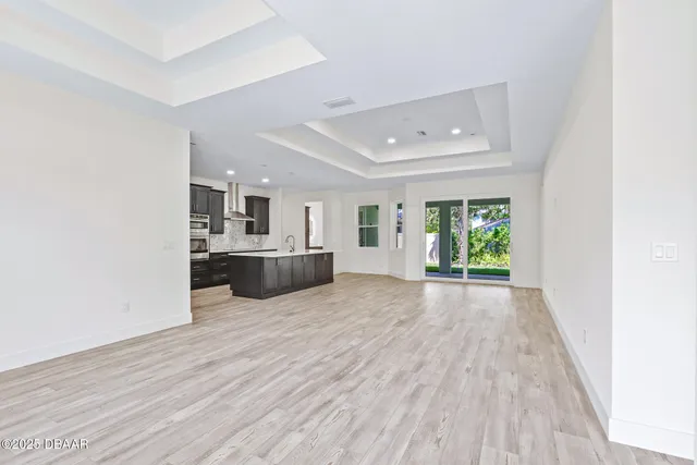 a view of a kitchen with furniture and wooden floor