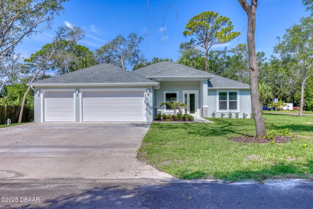 a front view of a house with a yard and trees