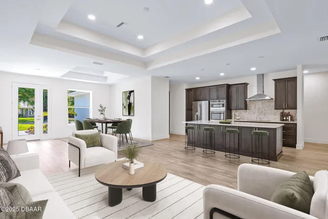 a living room with furniture and a view of kitchen