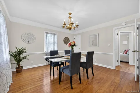 a view of a dining room with furniture wooden floor and chandelier