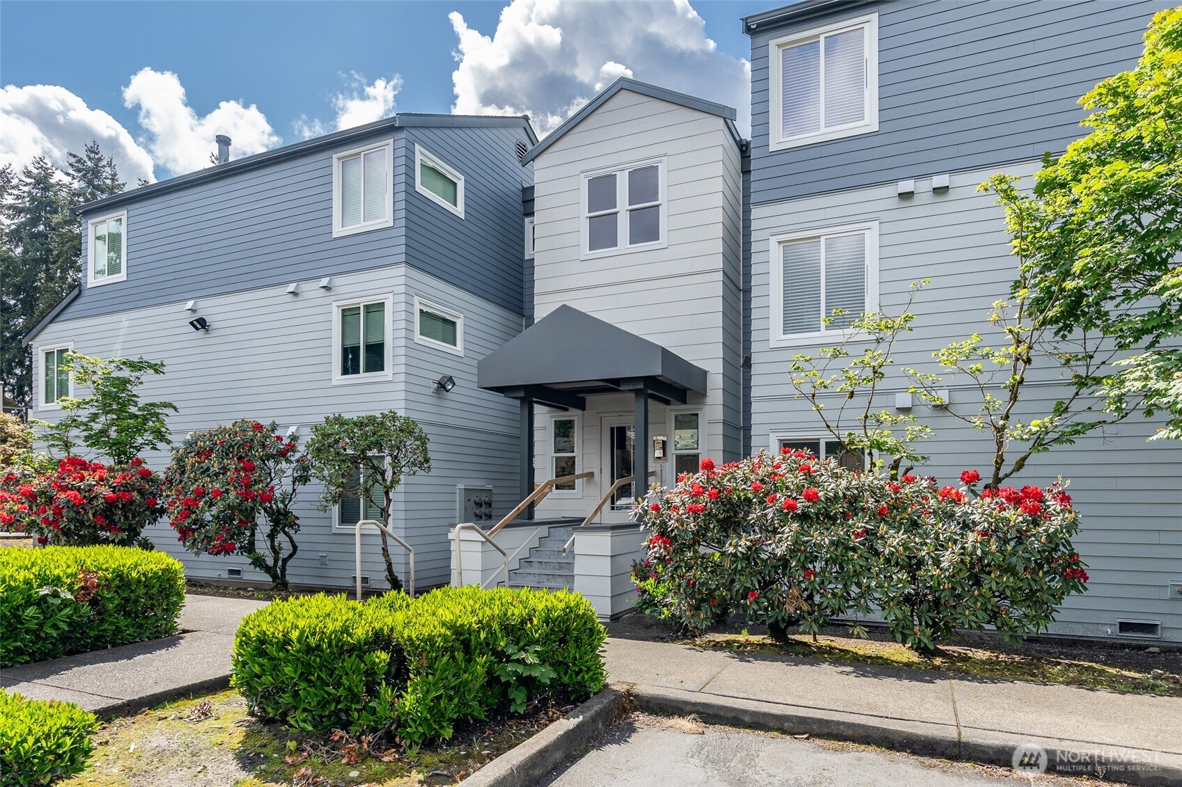 20320 Bothell Everett Highway, Unit D301 Bothell, WA 98012 - Photo 4 of 35 a front view of a house with a yard and a garden