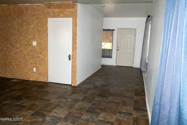 a view of a hallway with wooden floor and a bathroom