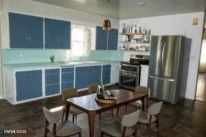 a kitchen with stainless steel appliances a table chairs and a refrigerator