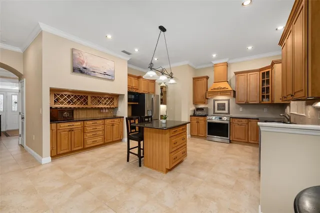 a large kitchen with stainless steel appliances granite countertop a stove and a sink
