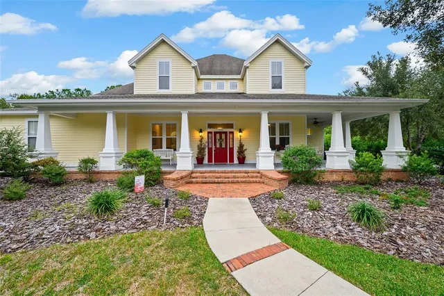 a view of house with garden and tall tress