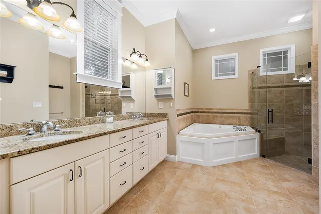 a spacious bedroom with a large bed and a chandelier