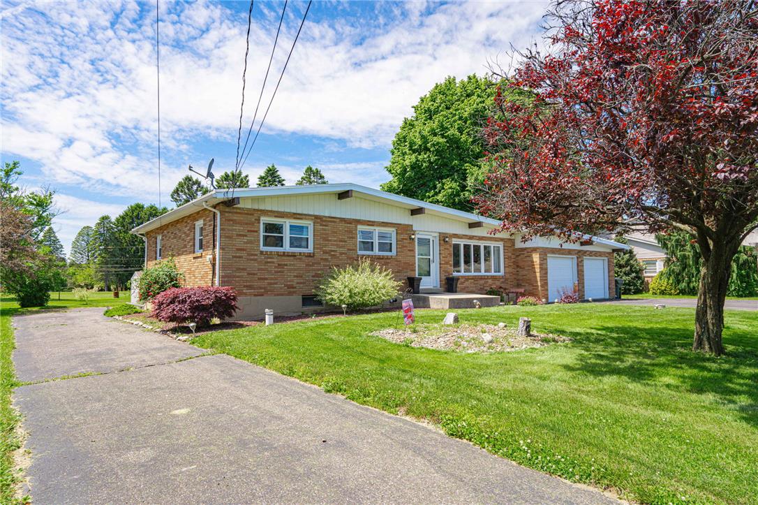 579 Cherry Road Northampton, PA 18067 - Photo 4 of 57 A classic brick ranch home with an attached garage, nestled on a verdant lawn under a bright sky.