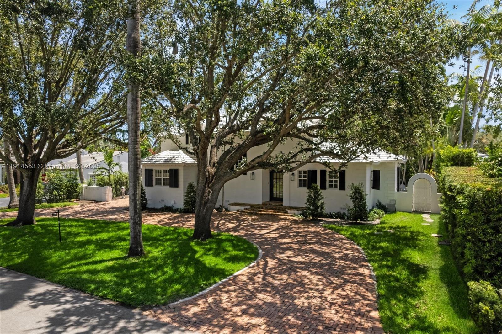 6675 Roxbury Lane Miami Beach, FL 33141 - Photo 15 of 40 a front view of a house with a garden and trees