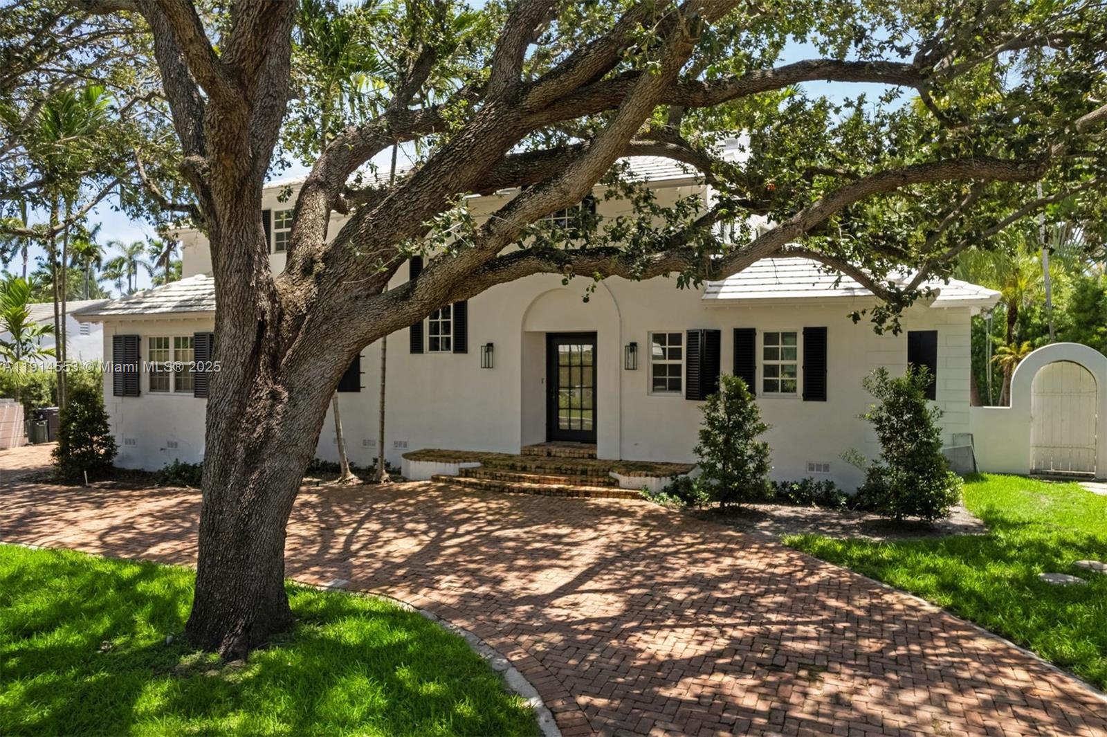 6675 Roxbury Lane Miami Beach, FL 33141 - Photo 2 of 40 a front view of a house with a garden
