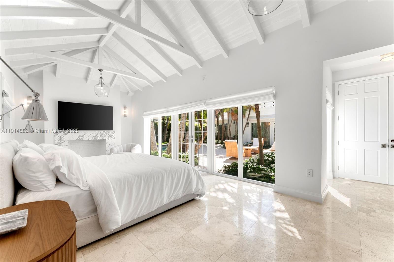 6675 Roxbury Lane Miami Beach, FL 33141 - Photo 32 of 40 a large white bed sitting in a room next to a window