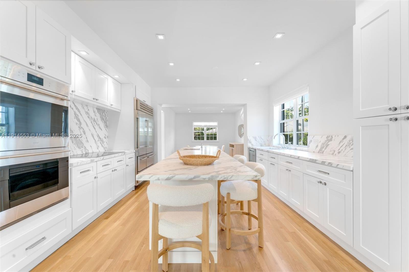 6675 Roxbury Lane Miami Beach, FL 33141 - Photo 34 of 40 a kitchen with granite countertop white cabinets stainless steel appliances and dining table