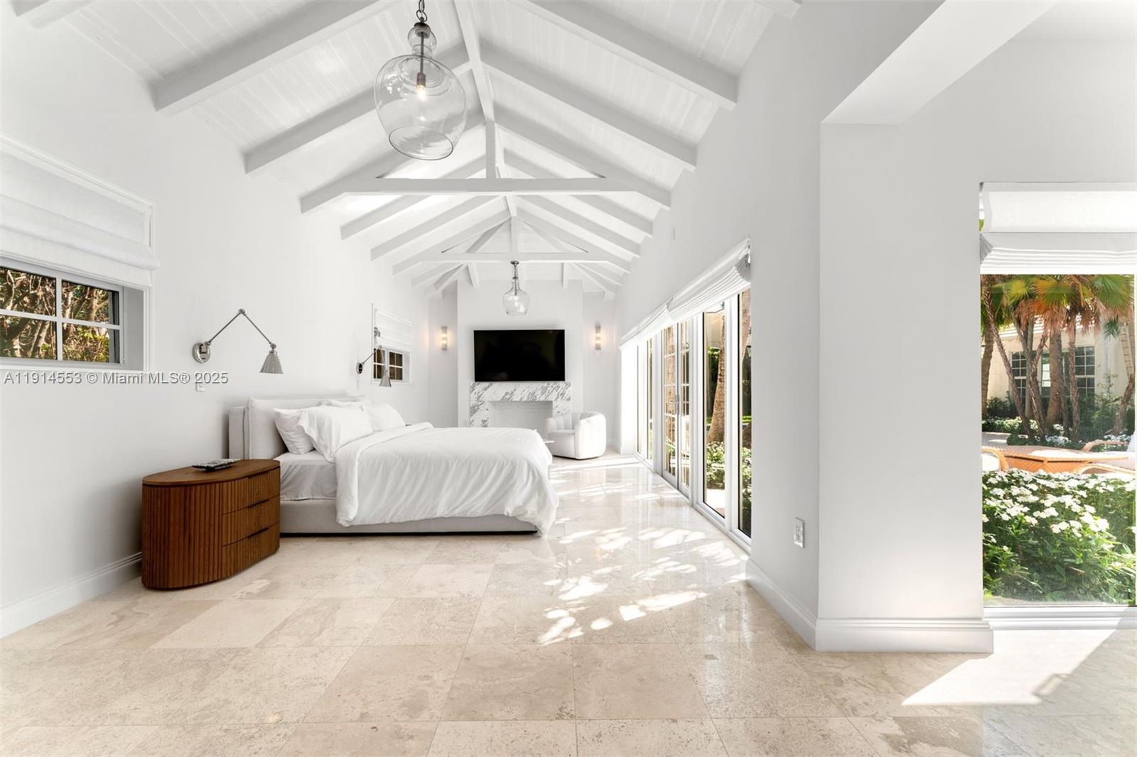 6675 Roxbury Lane Miami Beach, FL 33141 - Photo 35 of 40 a spacious bedroom with a large bed and a chandelier