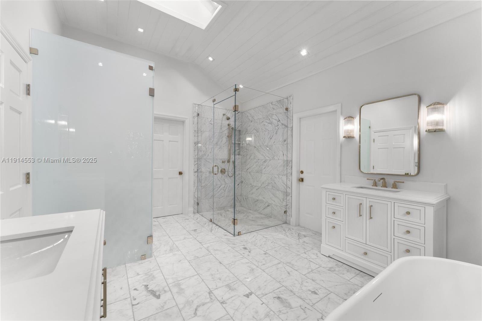 6675 Roxbury Lane Miami Beach, FL 33141 - Photo 5 of 40 a bathroom with a granite countertop sink a toilet a mirror and shower