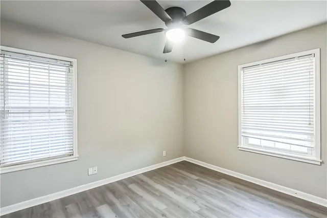 an empty room with a window and a fan