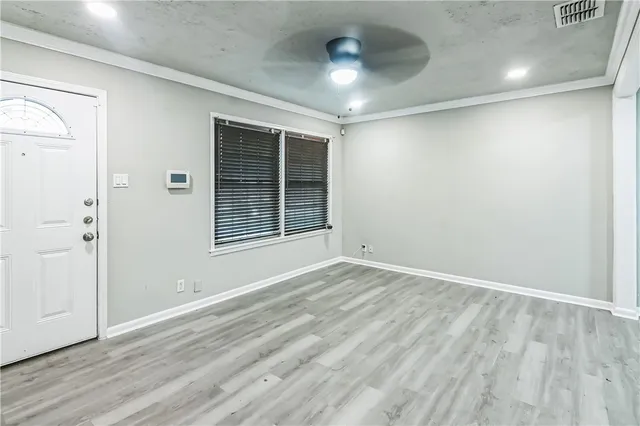 an empty room with wooden floor and windows