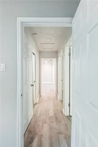 a view of a hallway with wooden shelves