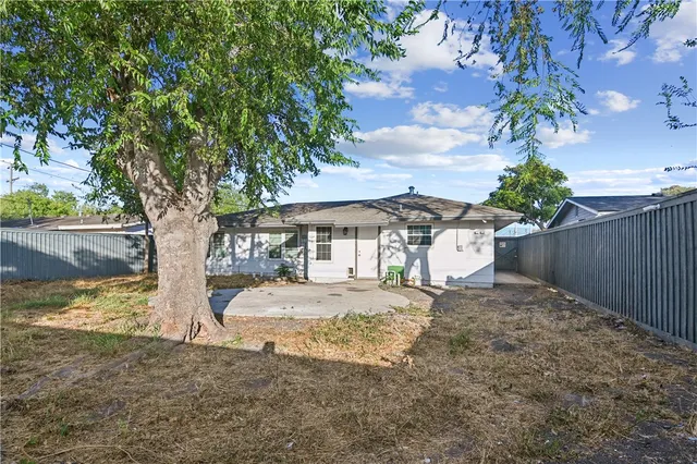a white house that has a tree in front of it