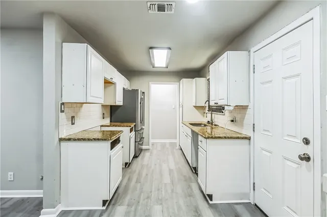 a kitchen with stainless steel appliances granite countertop a sink stove and refrigerator