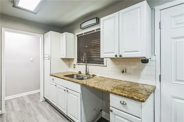 a kitchen with granite countertop a sink and cabinets