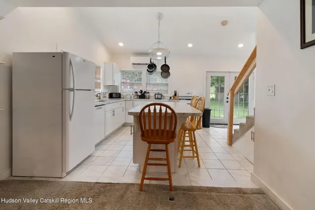 a kitchen with stainless steel appliances granite countertop a refrigerator a stove a sink a dining table and chairs