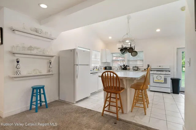 a kitchen with a table chairs refrigerator and microwave