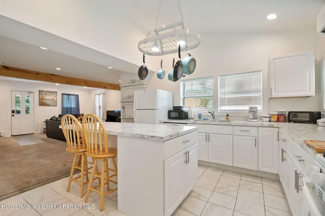 a kitchen with stainless steel appliances kitchen island granite countertop a stove a sink and a refrigerator