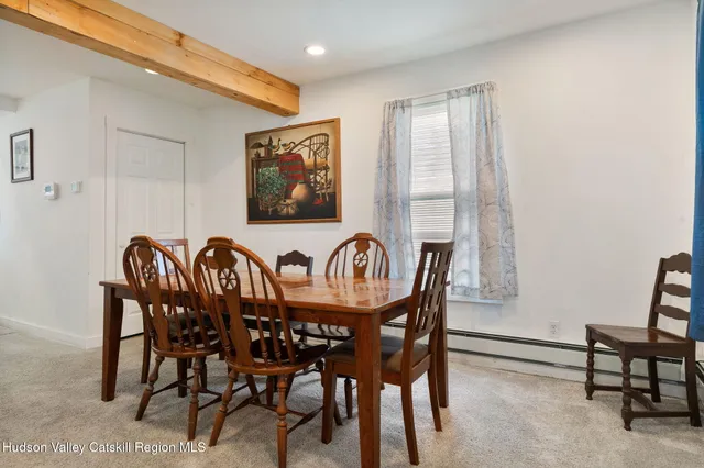 a view of a a dining room with furniture window and wooden floor
