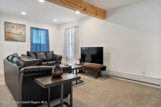 a living room with furniture a flat screen tv and a window
