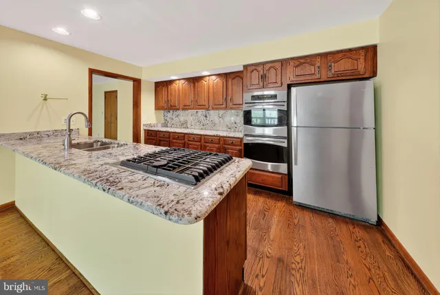 a kitchen with kitchen island a counter top space a sink and refrigerator