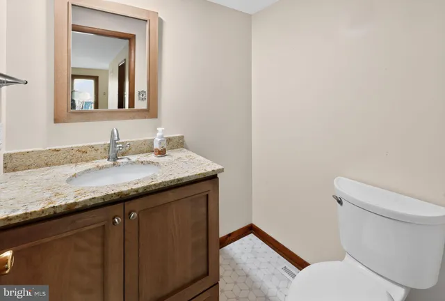 a bathroom with a granite countertop sink and a mirror