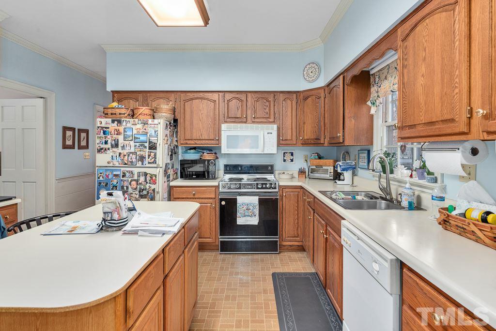 2416 Basil Drive Raleigh, NC 27612 - Photo 11 of 26 a kitchen with stainless steel appliances granite countertop a sink stove and refrigerator