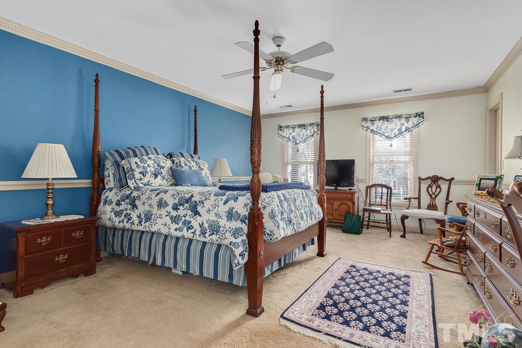 2416 Basil Drive Raleigh, NC 27612 - Photo 16 of 26 a bedroom with a bed rug and lamp