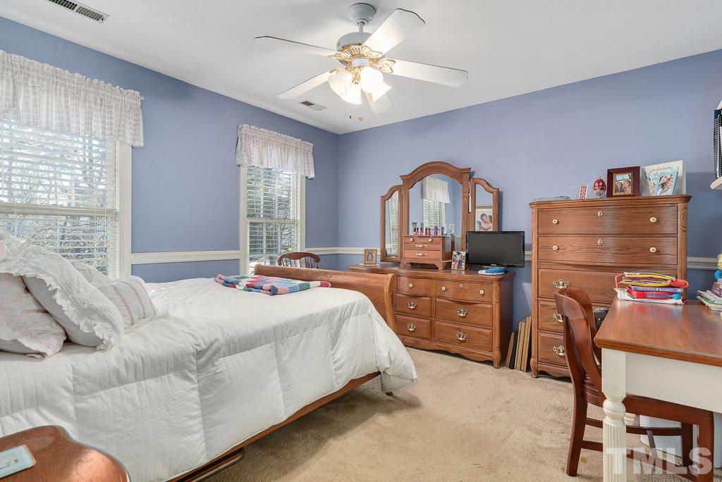 2416 Basil Drive Raleigh, NC 27612 - Photo 21 of 26 a bed room with a bed and a chandelier