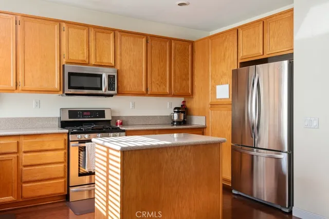a kitchen with granite countertop wooden cabinets and stainless steel appliances