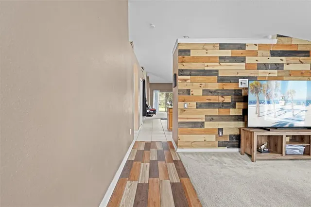 a kitchen with kitchen island granite countertop a refrigerator a sink a stove and white cabinets with wooden floor