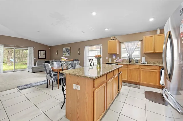 a kitchen with stainless steel appliances granite countertop a sink refrigerator stove and microwave