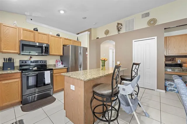 a dining room with kitchen island furniture a large window and kitchen view