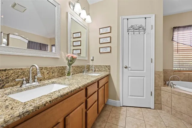 a bathroom with a sink a tub and a mirror