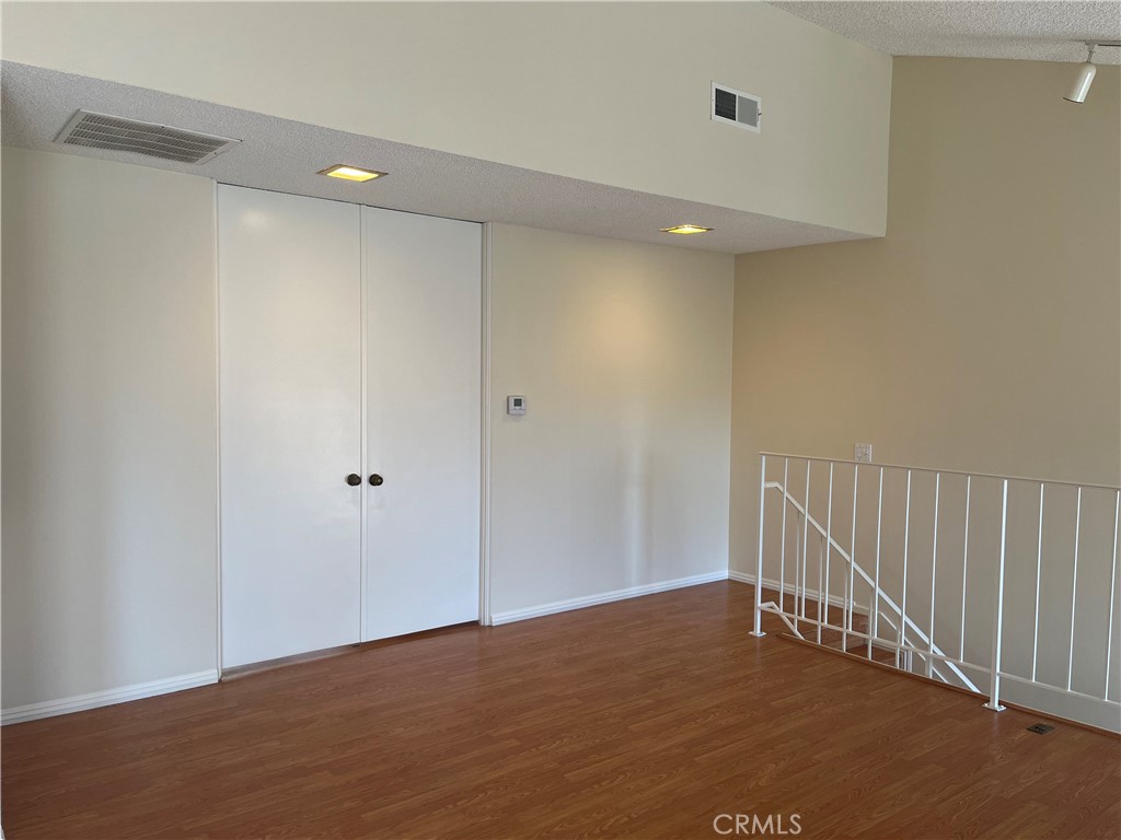 19547 Rinaldi Street, Unit 27 Porter Ranch, CA 91326 - Photo 11 of 20 a view of an empty room with wooden floor