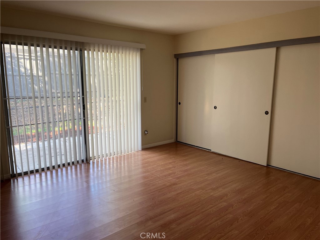 19547 Rinaldi Street, Unit 27 Porter Ranch, CA 91326 - Photo 13 of 20 a view of an empty room with wooden floor and a window