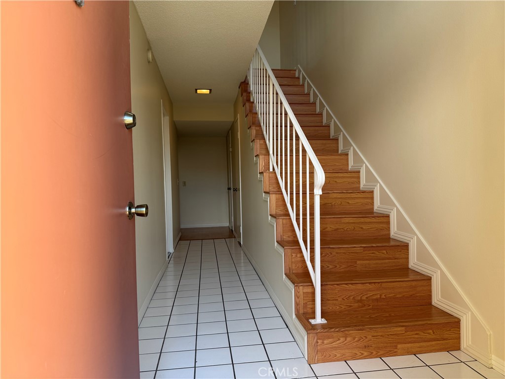 19547 Rinaldi Street, Unit 27 Porter Ranch, CA 91326 - Photo 20 of 20 a view of a hallway with wooden floor and entryway