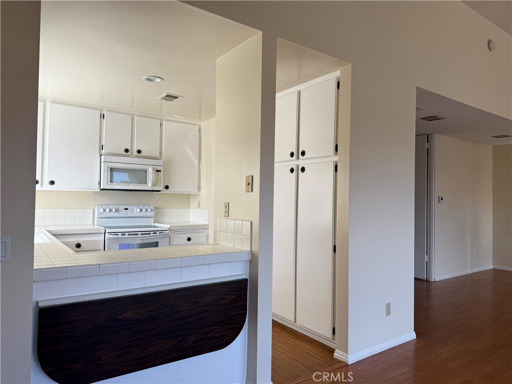 19547 Rinaldi Street, Unit 27 Porter Ranch, CA 91326 - Photo 5 of 20 a kitchen with stainless steel appliances a stove a refrigerator and cabinets