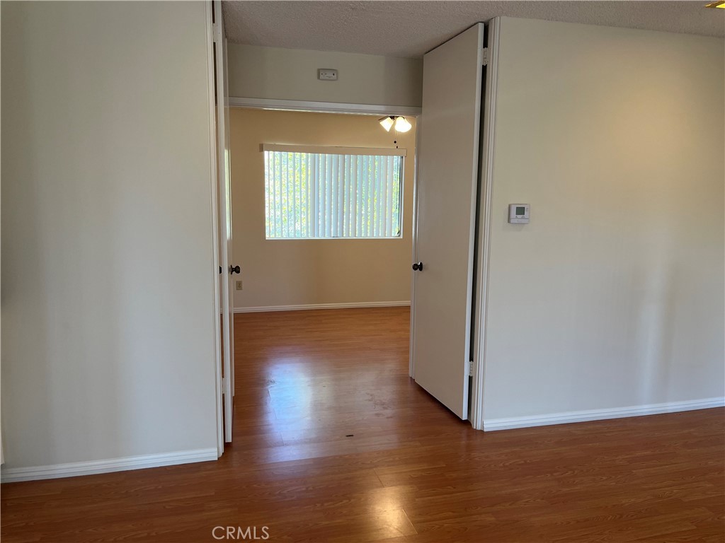 19547 Rinaldi Street, Unit 27 Porter Ranch, CA 91326 - Photo 10 of 20 an empty room with wooden floor and windows
