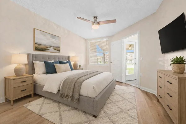a spacious bedroom with a bed and a flat screen tv