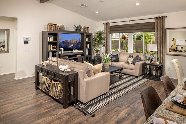 a living room with furniture a flat screen tv and a large window